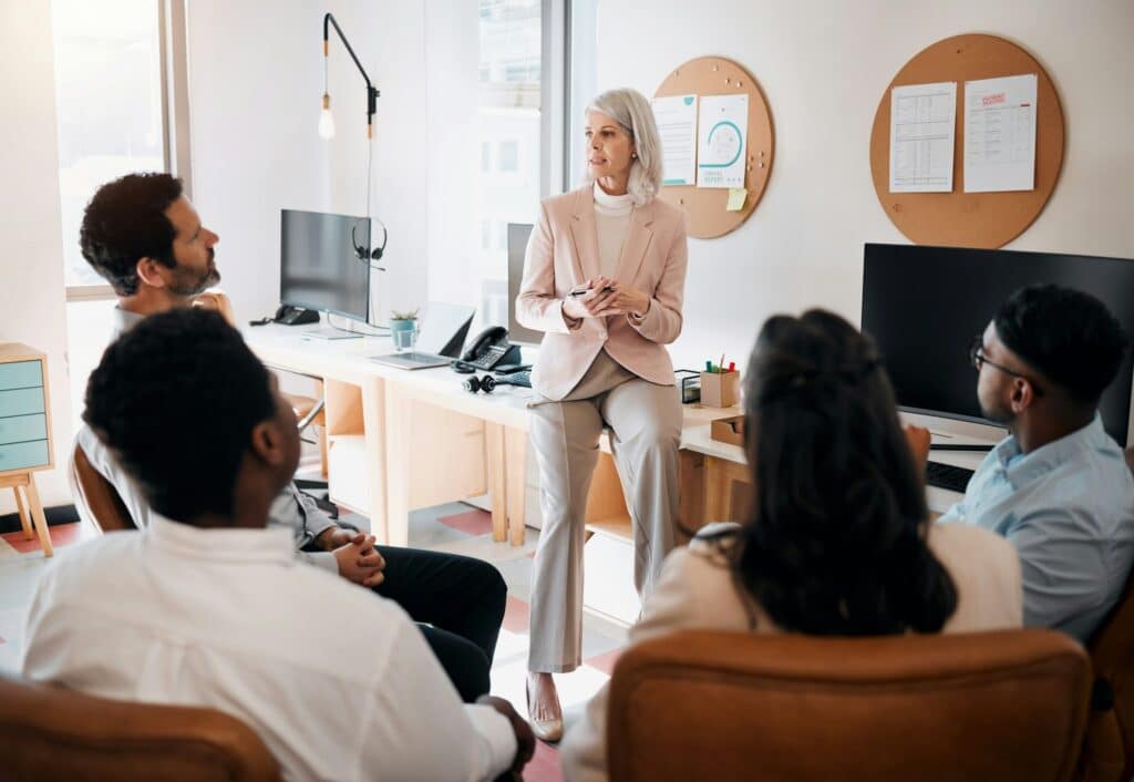 Any questions. Shot of a mature businesswoman sitting and training her team in the office.